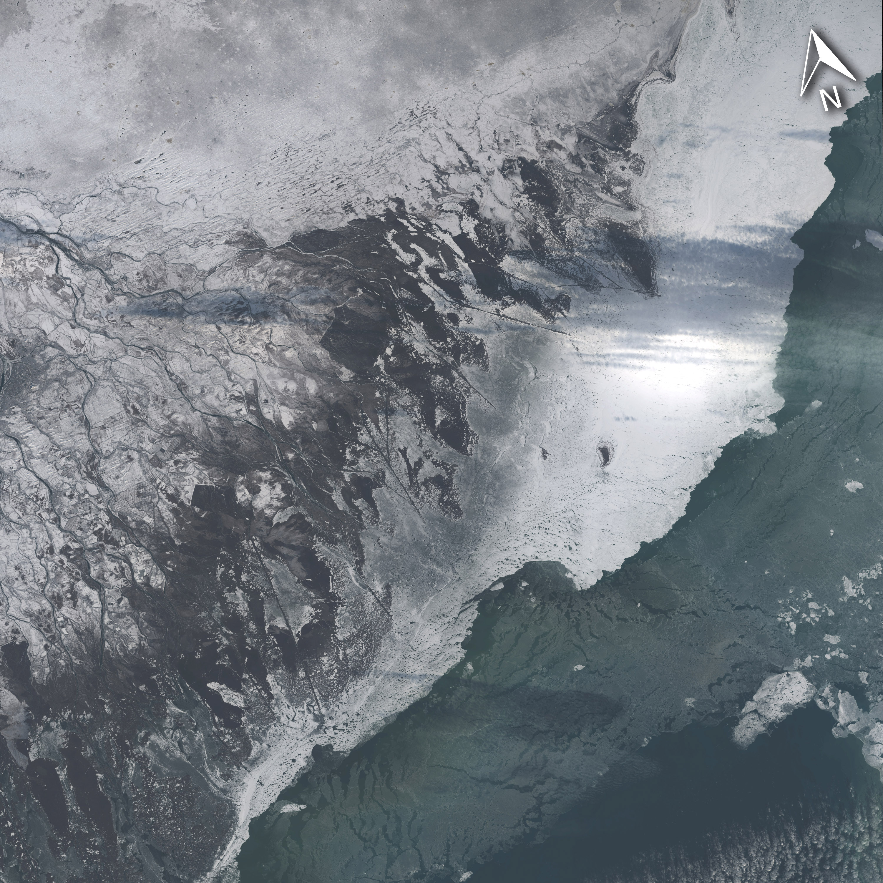 La misma zona que en la imagen anterior, fotografiada el pasado día 4 de Diciembre, pero con el hielo acumulandose en la línea de costa del delta. Landsat/NASA.