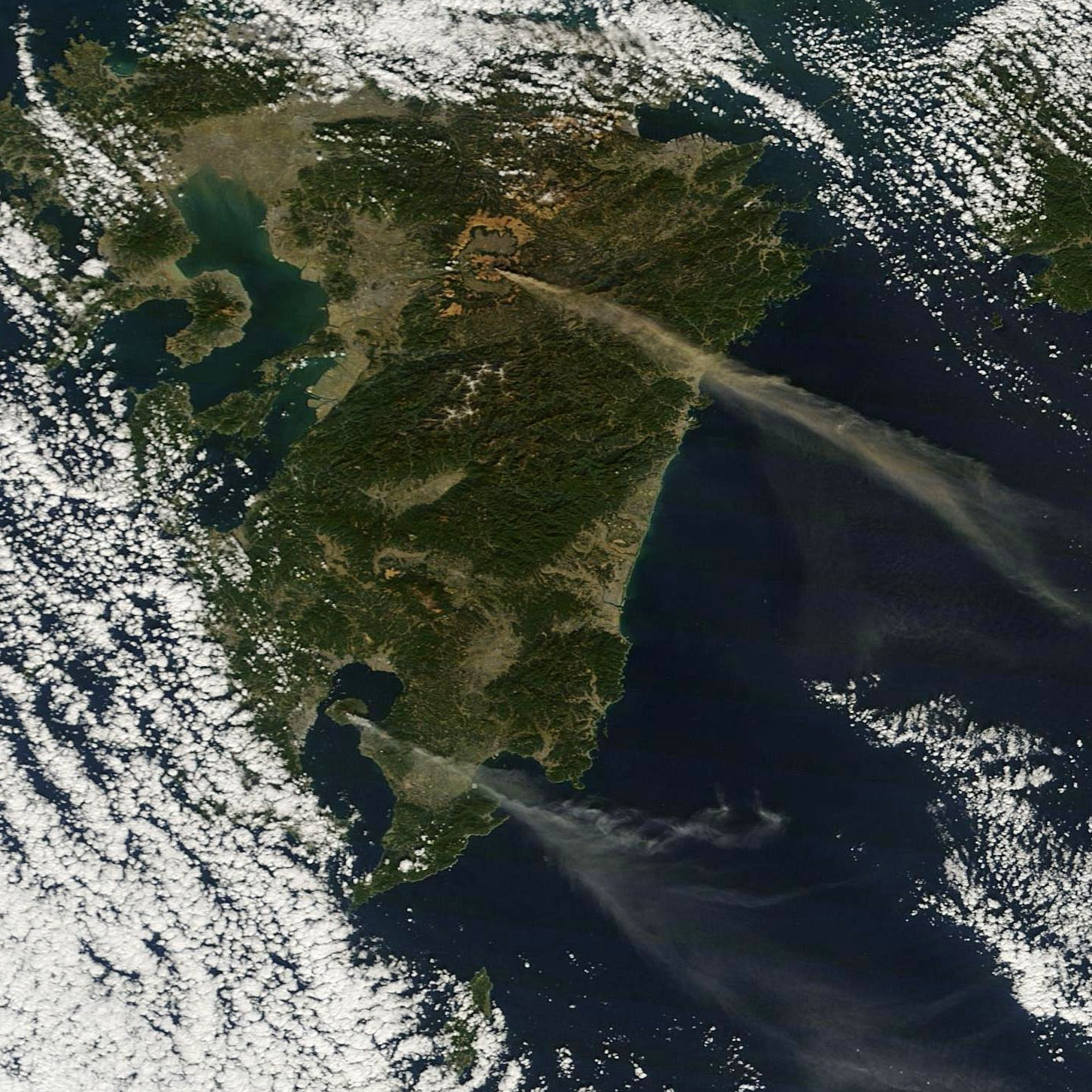 Los volcanes Aso y Sakurajima pillados simultaneamente emitiendo gases y cenizas. NASA.