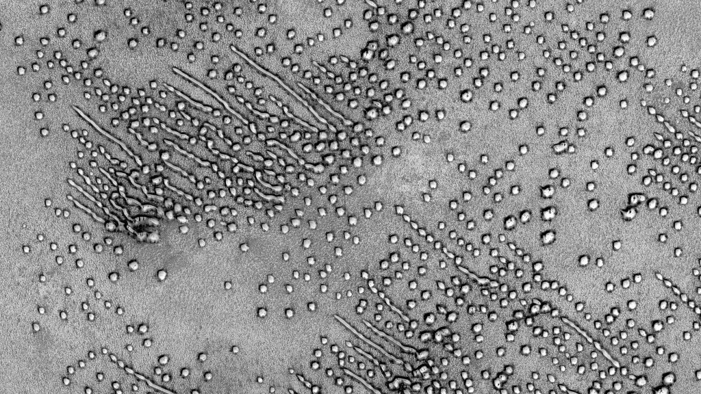 Aunque parezca una fotografía de microscopio electrónico o una partitura escrita en código Morse, en realidad estamos viendo un campo de dunas marciano cercano al polo norte.  